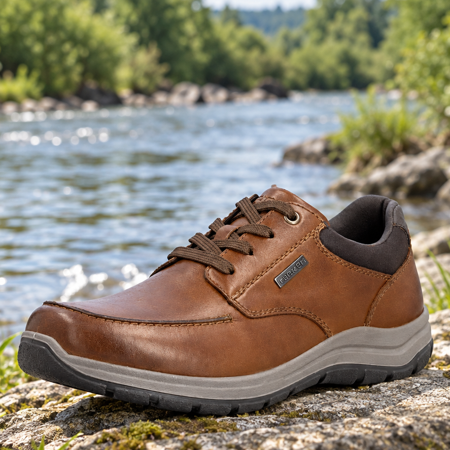 Men's brown leather lace-up shoe on a rocky surface with chunky rubber sole