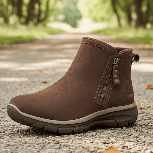 Women's chocolate suede ankle boots with side zipper on outdoor walkway