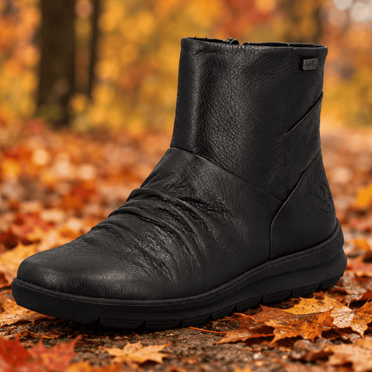 Women's black leather ankle boot with side seam detail and rugged tread outsole