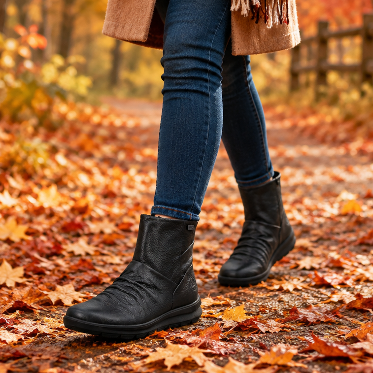 Women's black leather ankle boots worn with blue jeans