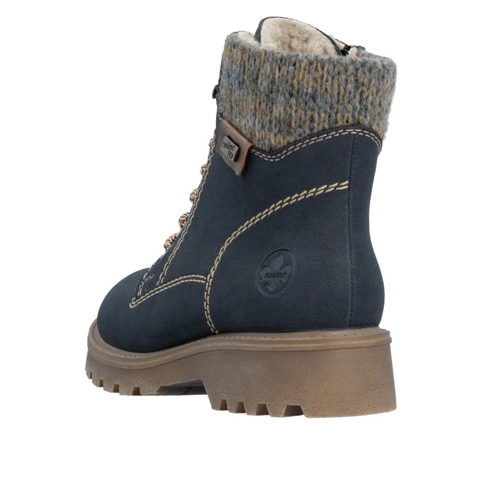 Blue biker ankle boot with fuzzy cuff, side stitching, and tan treaded sole