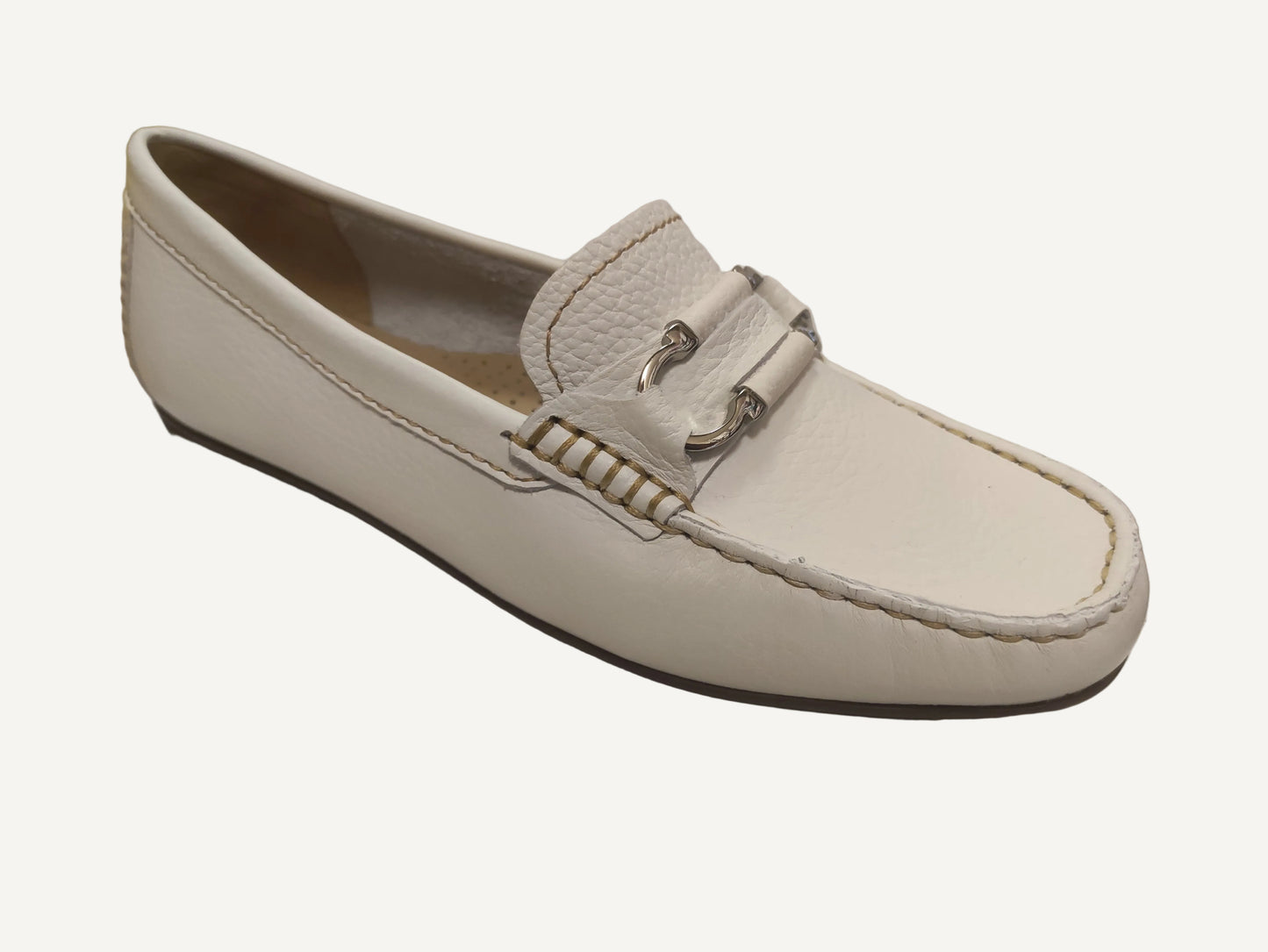 White loafer shoe on a white surface with a blurred background