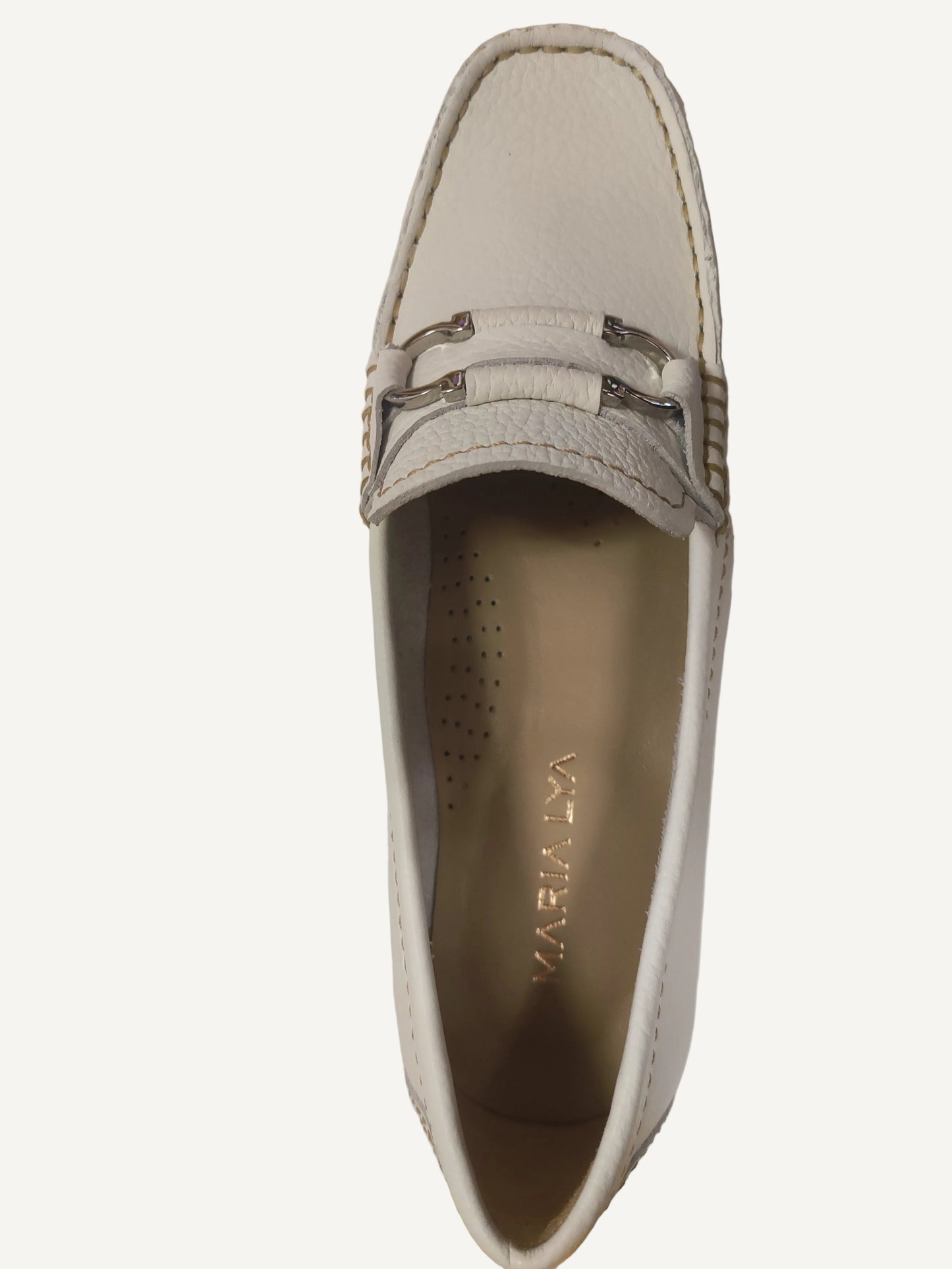 White shoe with a decorative buckle on a white surface