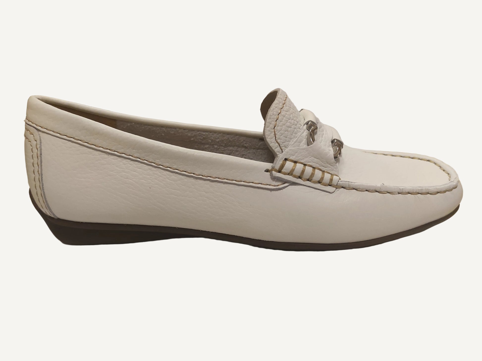 White loafer shoe on a white surface with a blurred background
