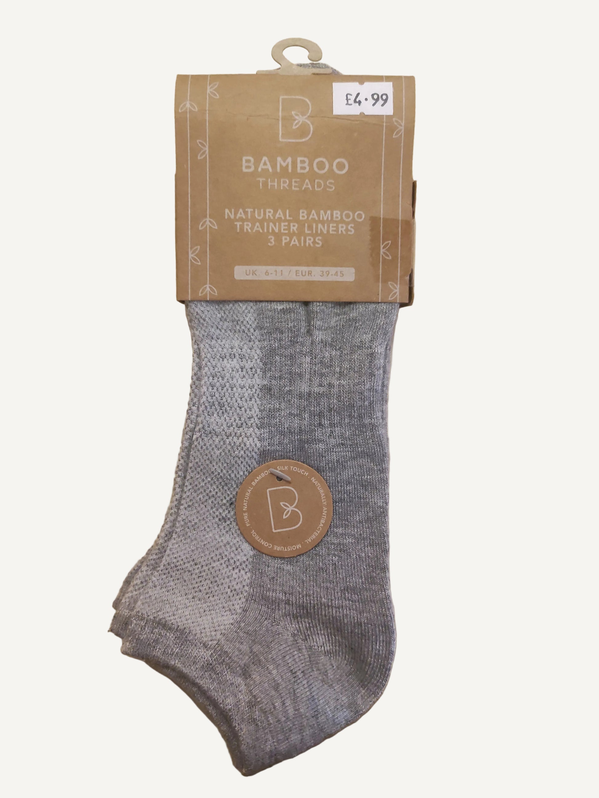 Gray ankle sock with a brand logo on a wooden surface