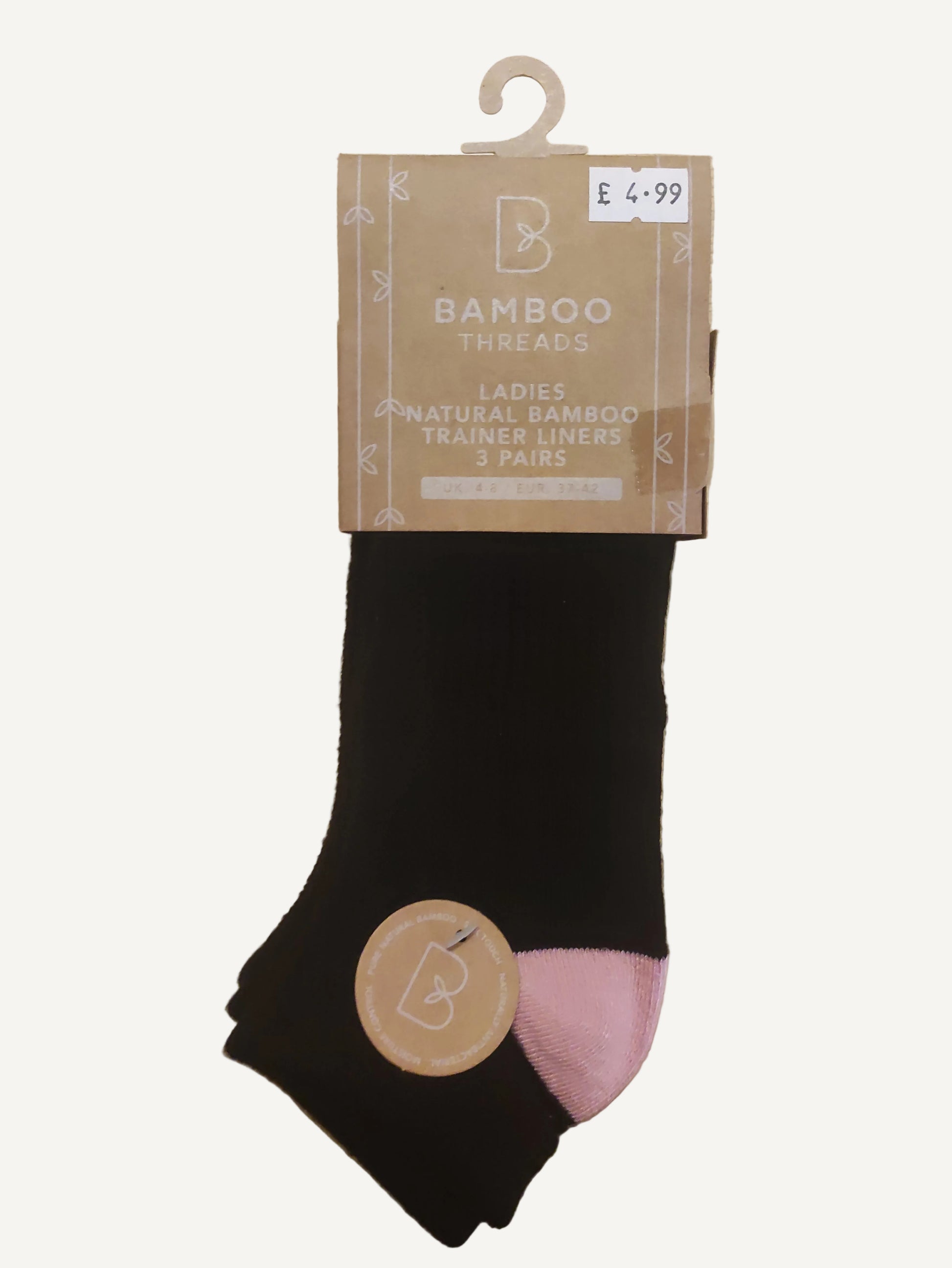 Black and pink socks with packaging on a wooden surface