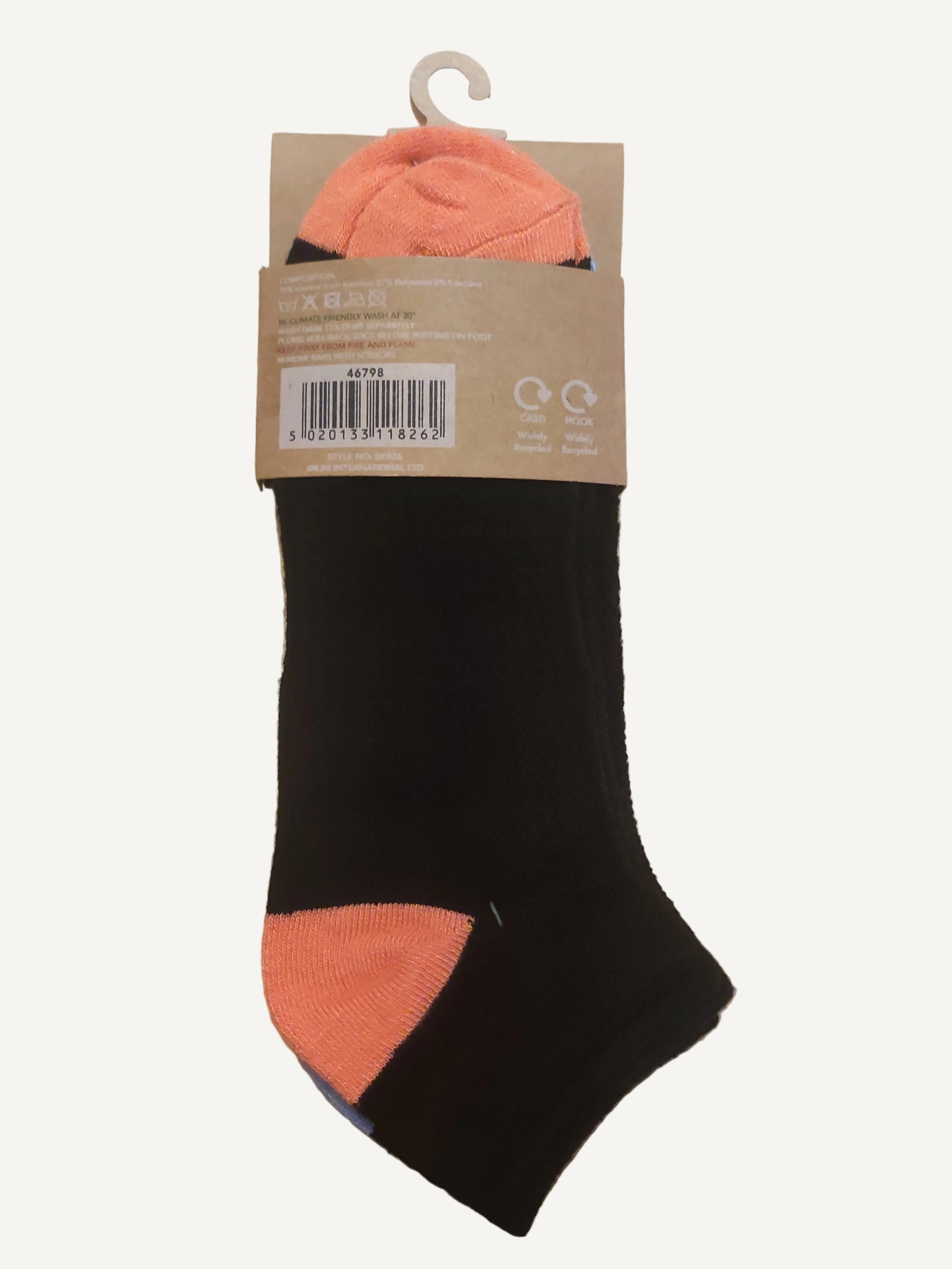 Black and orange sock with a label on a wooden surface