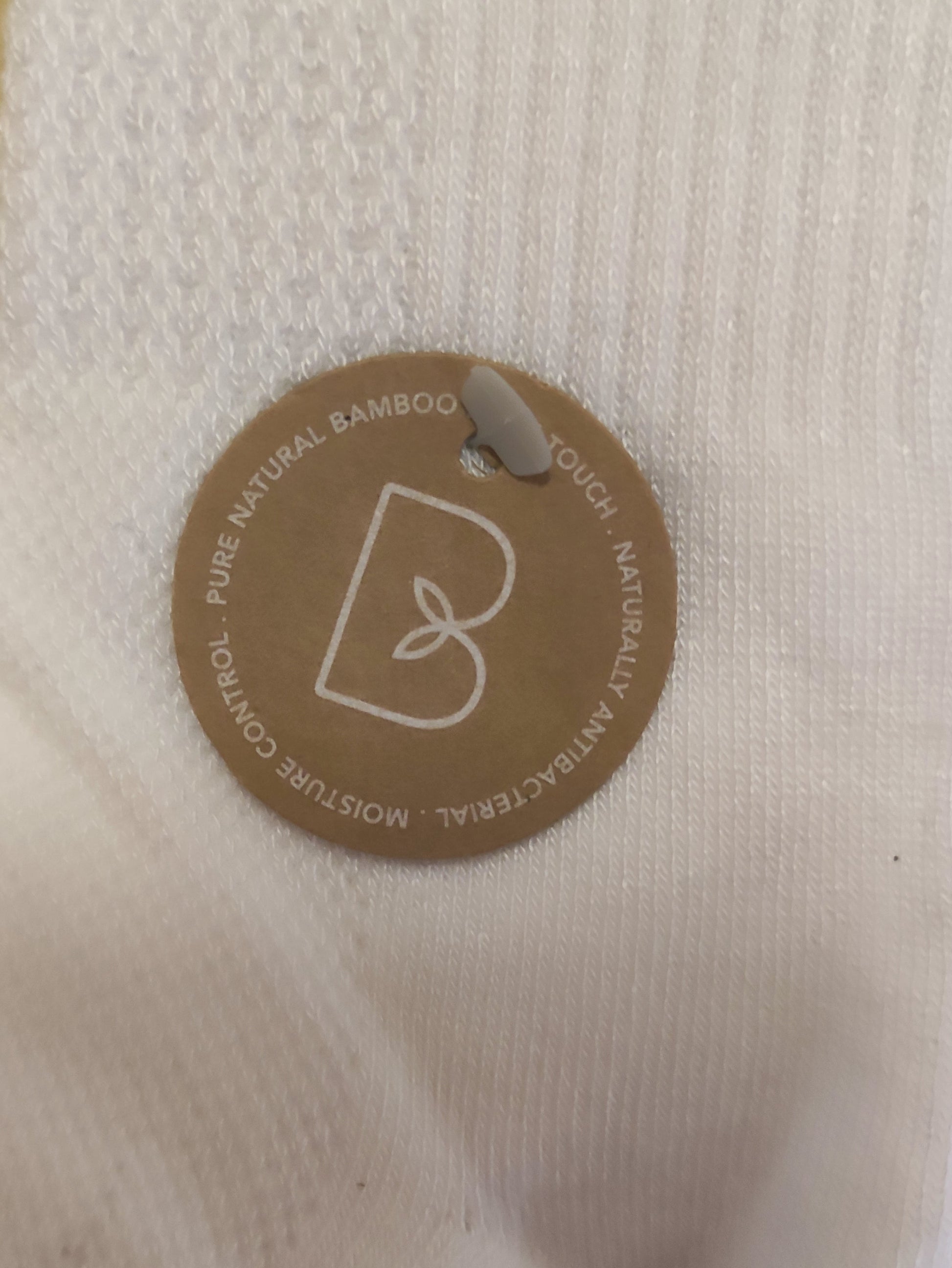 White sock with a brown label on a wooden surface