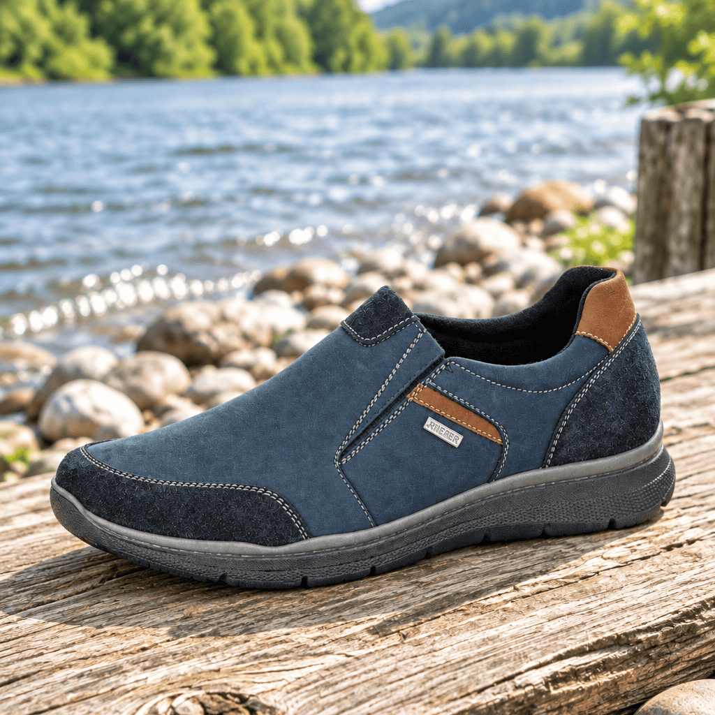 Men's navy waterproof slip-on shoe with stitched upper, tan heel panel, and rubber sole