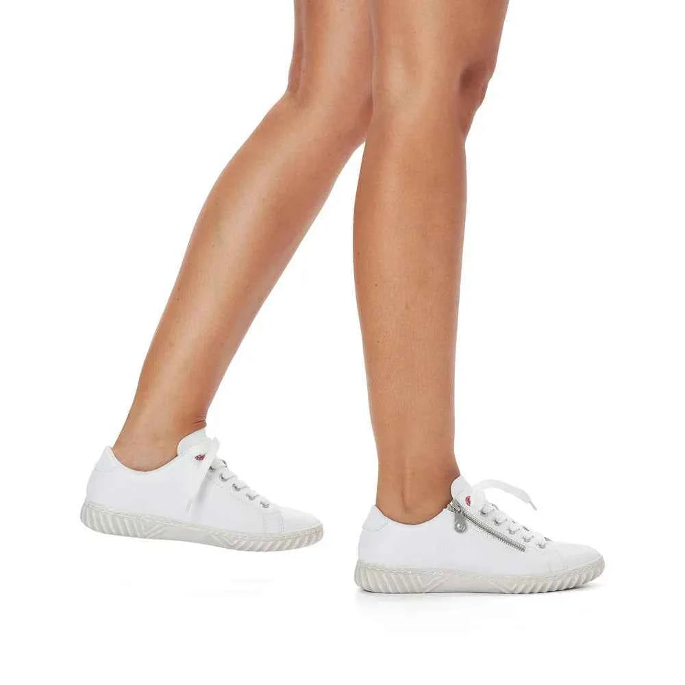 White Rieker casual lace-up sneakers worn on feet with textured soles by Woodley's Shoes