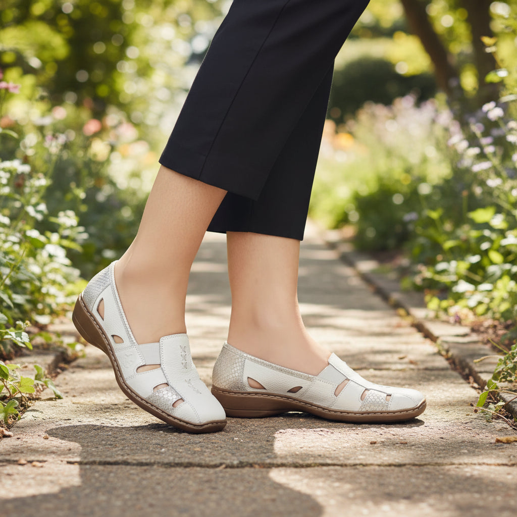 White sandals with brown soles worn by a person on a white background