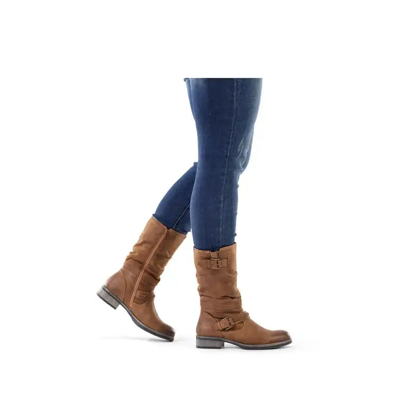 Brown tall boots with buckle straps, worn with blue jeans