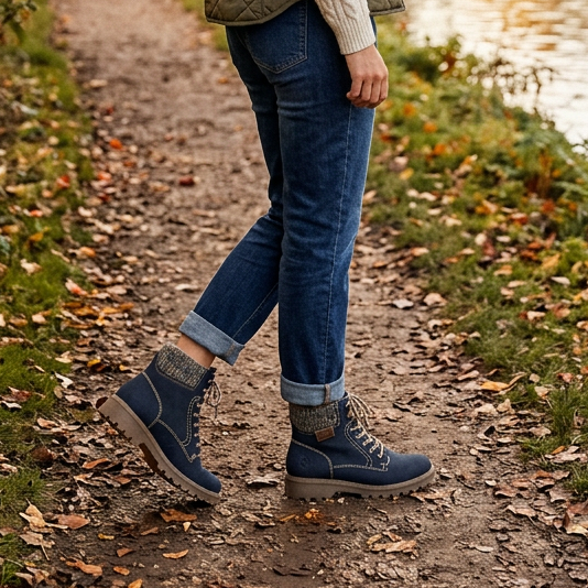 Pair of blue lace-up biker ankle boots worn with dark jeans