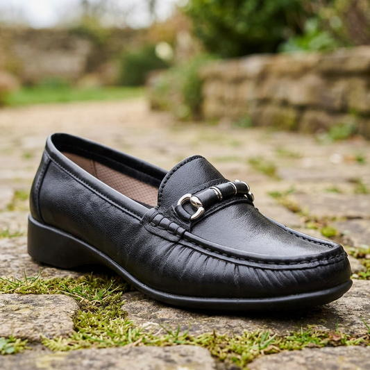 Black leather women's moccasin with metal buckle strap and side seam stitching