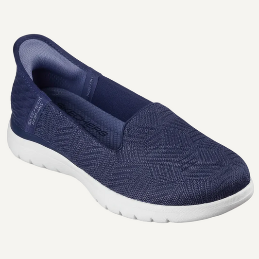 Navy slip-on shoe with white sole on a beige background