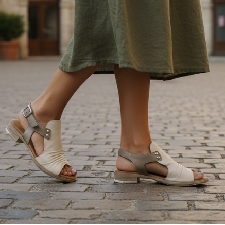 Person wearing beige sandals on a cobblestone street with a blurred background